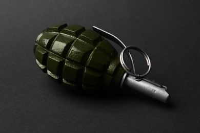 Photo of Hand grenade on black background, closeup. Explosive weapon