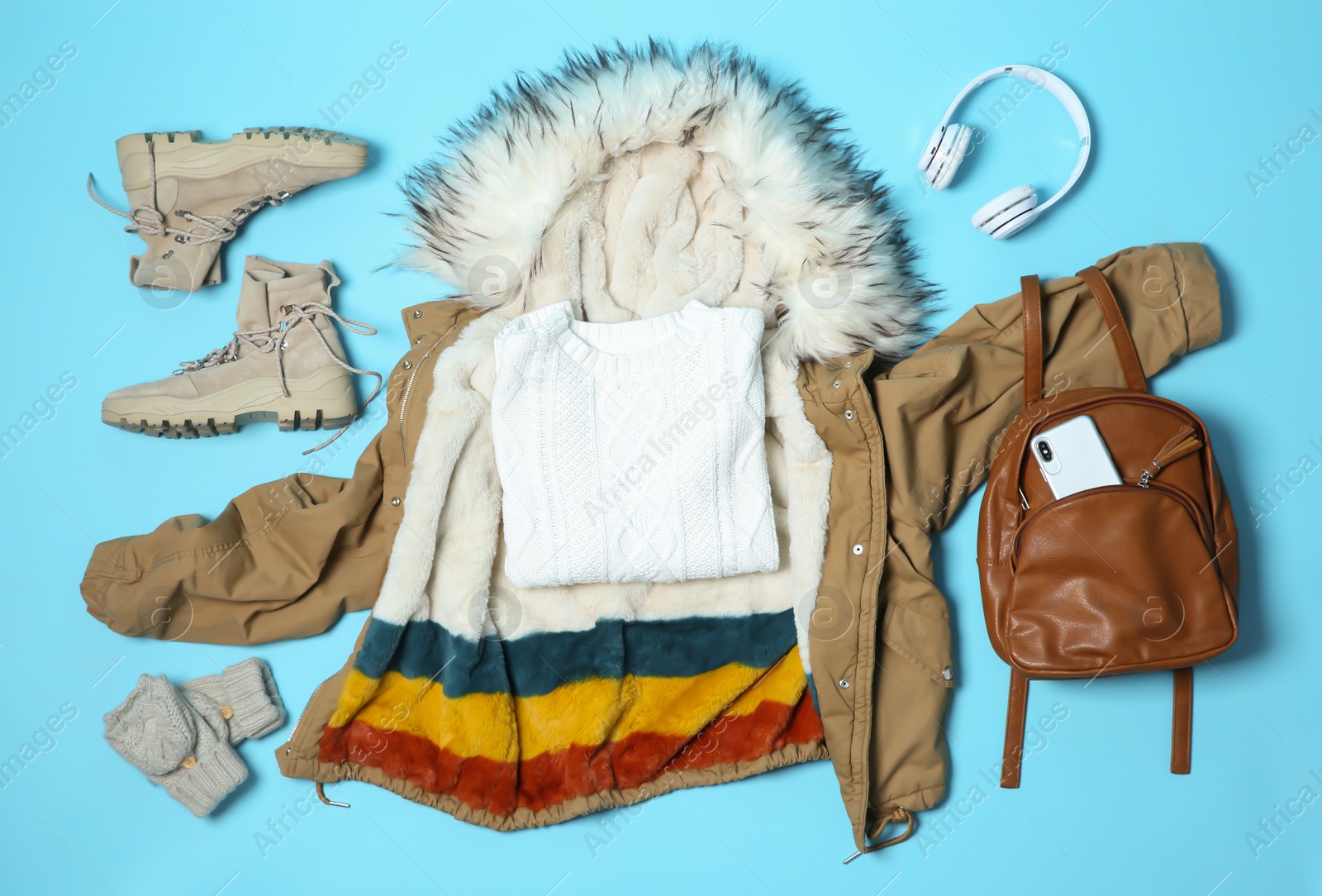 Photo of Flat lay composition with warm clothes for winter vacation on color background