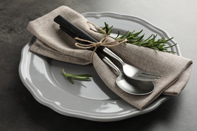 Stylish setting with cutlery and napkin on black table