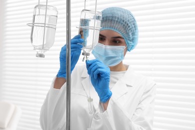 Photo of Nurse setting up IV drip in hospital