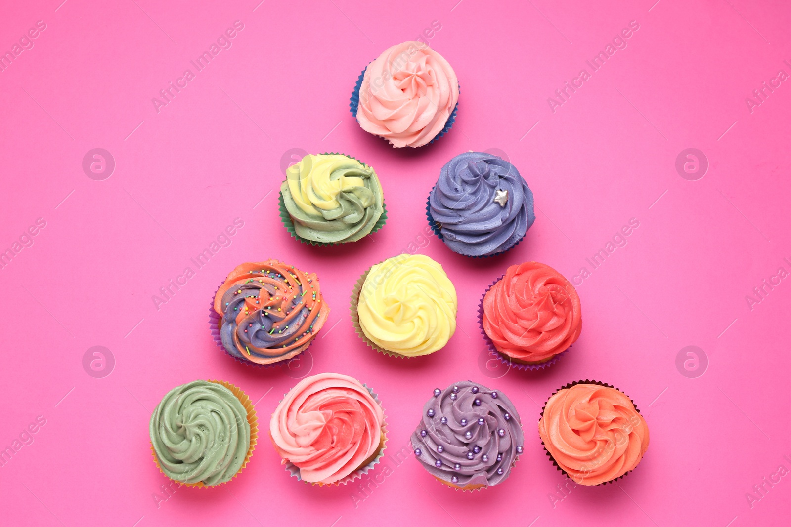 Photo of Delicious cupcake with bright cream on pink background, flat lay