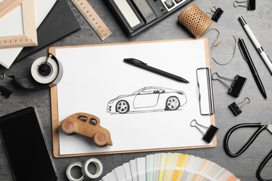 Photo of Flat lay composition with drawing of car on grey table. Designer's workplace
