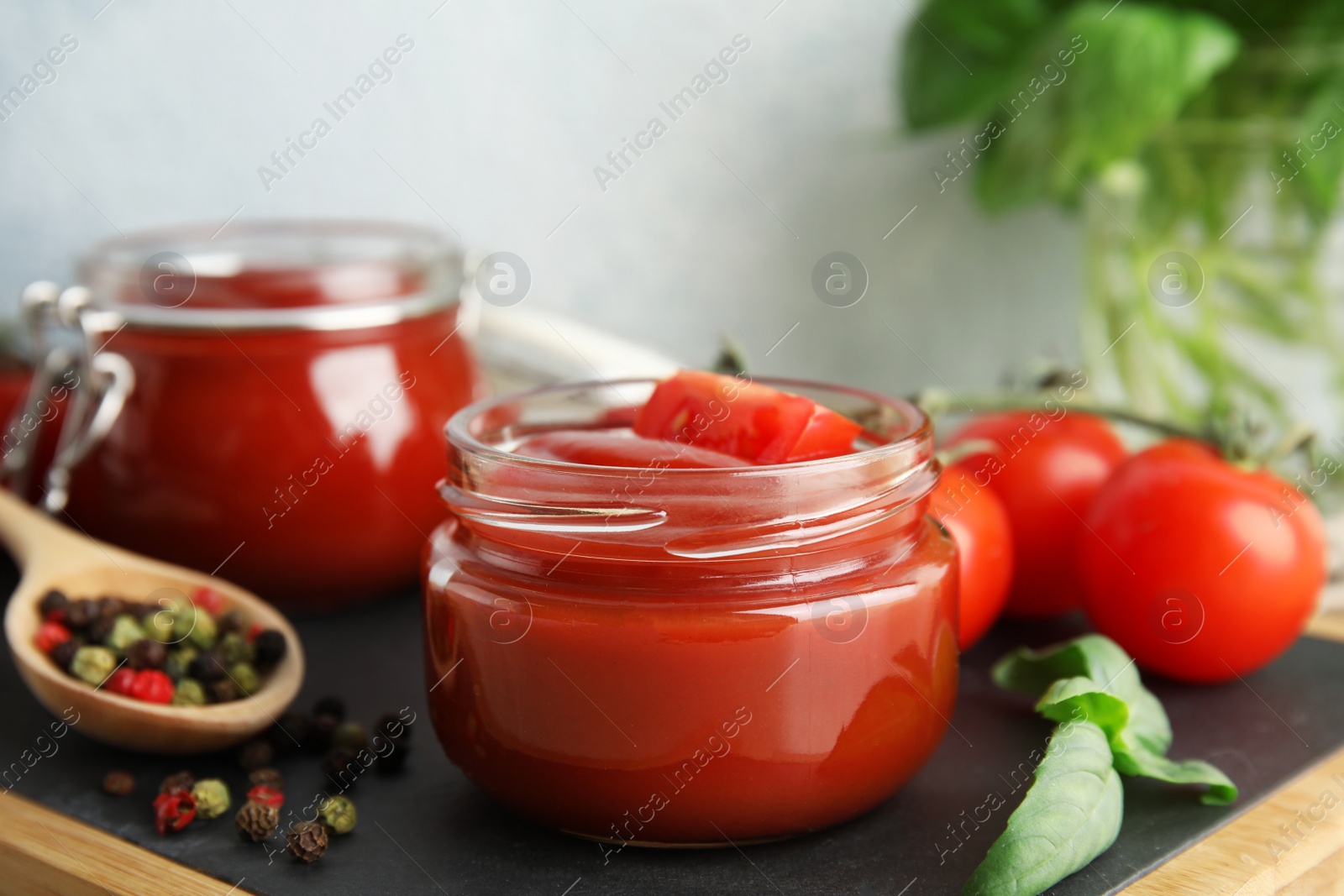 Photo of Composition with tomato sauce in jars on table