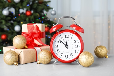 Photo of Retro alarm clock, gifts and festive decor on table. Christmas countdown