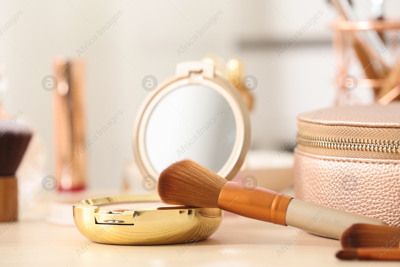 Photo of Pocket powder with brush on dressing table, closeup