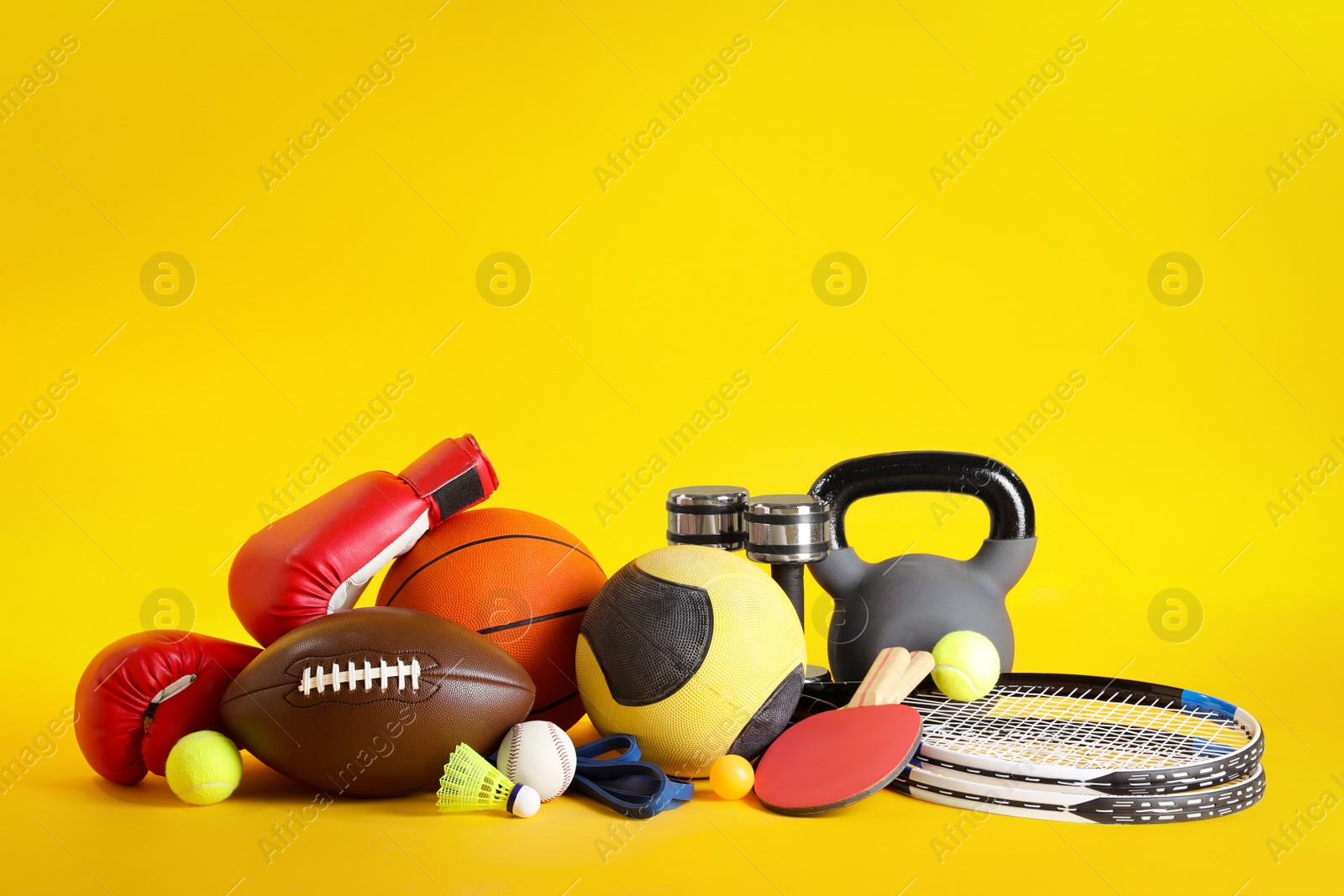 Photo of Set of different sports equipment on yellow background