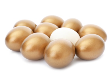 Photo of Ordinary egg among golden ones on white background