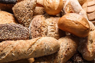 Photo of Different kinds of fresh bread as background, closeup