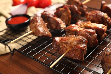 Photo of Delicious shish kebabs on wooden table, closeup
