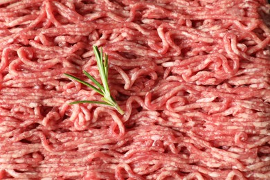 Photo of Raw ground meat and rosemary as background, top view