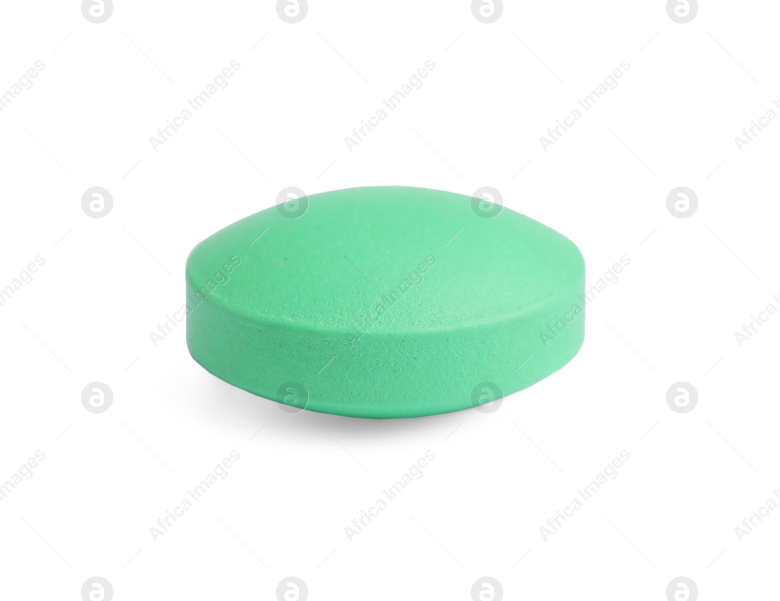 Photo of One light green pill on white background. Medicinal treatment