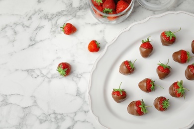 Photo of Flat lay composition with chocolate covered strawberries on marble background