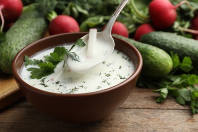 Delicious cold summer soup with kefir served on wooden table