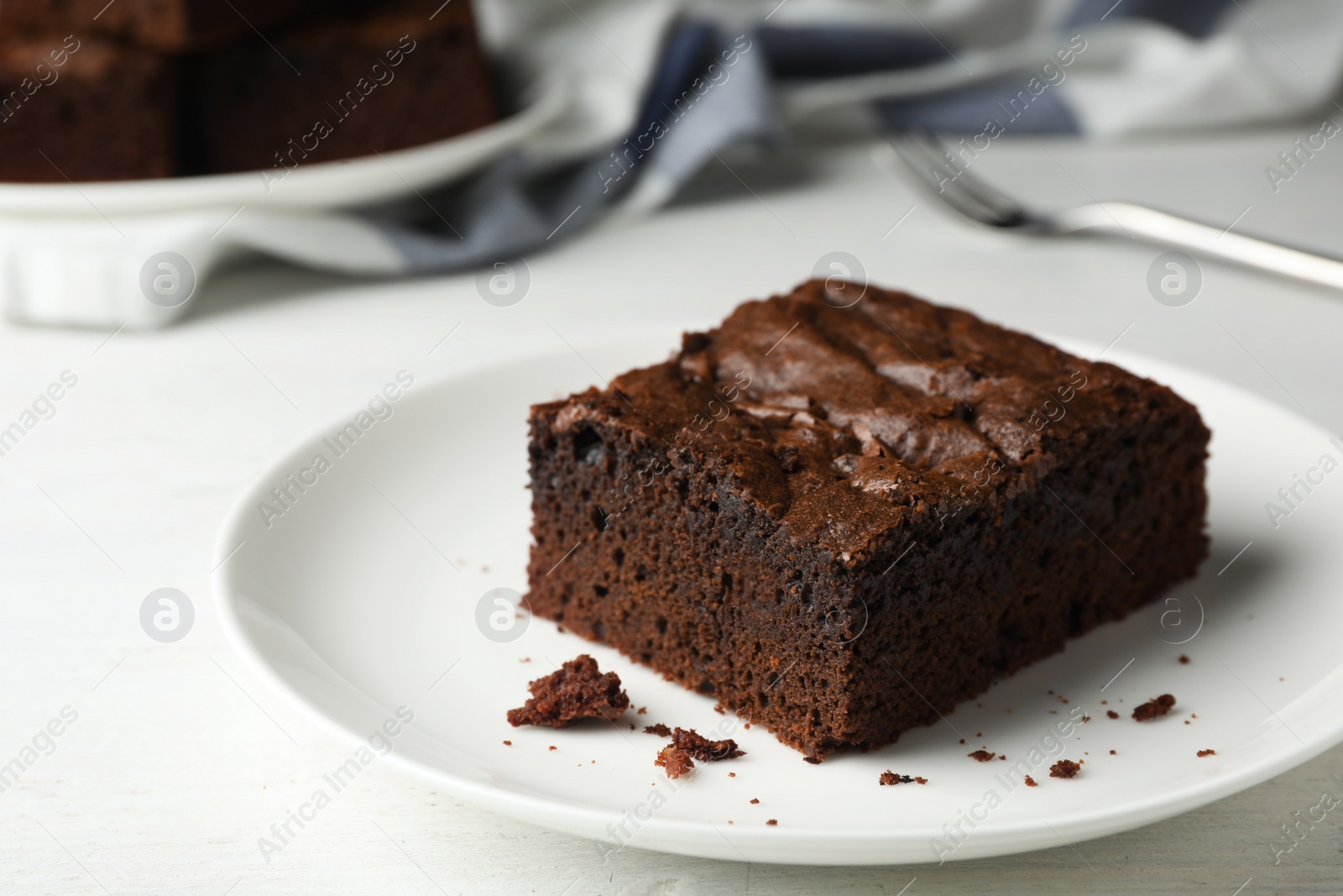 Photo of Plate with fresh brownie on white table, space for text. Delicious chocolate pie