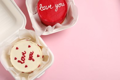 Photo of St. Valentine's day surprise. Bento cakes in takeaway boxes on pink table, flat lay. Space for text