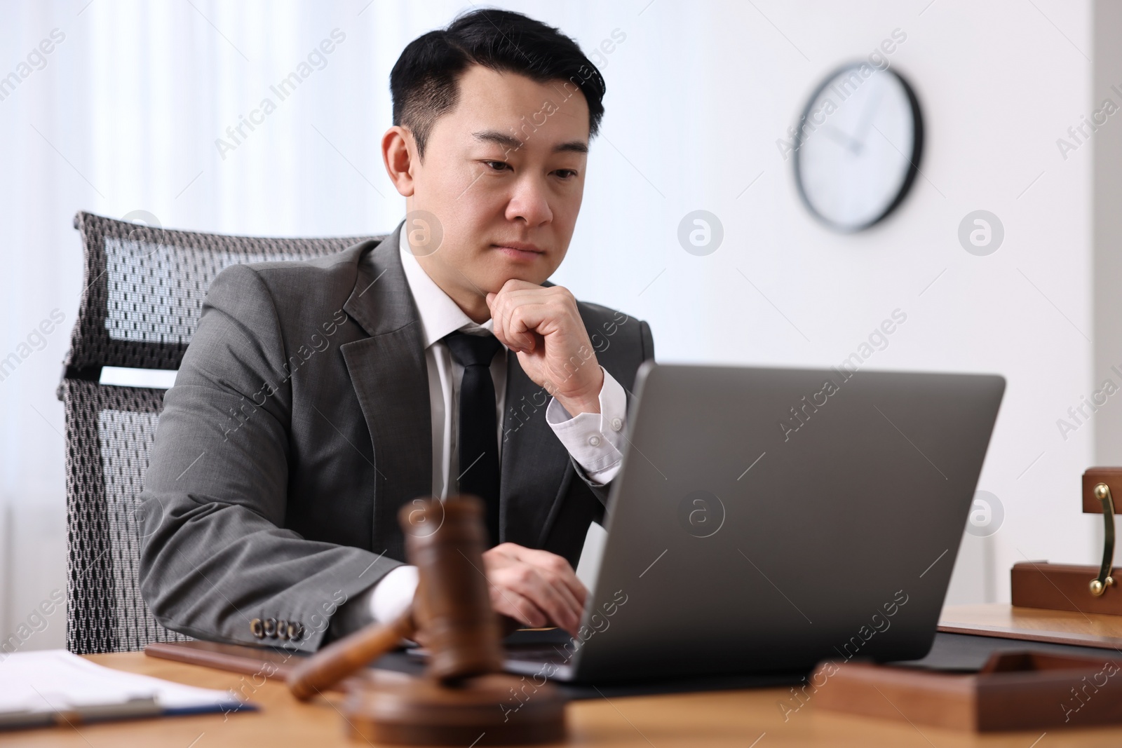 Photo of Notary working with laptop at wooden table in office