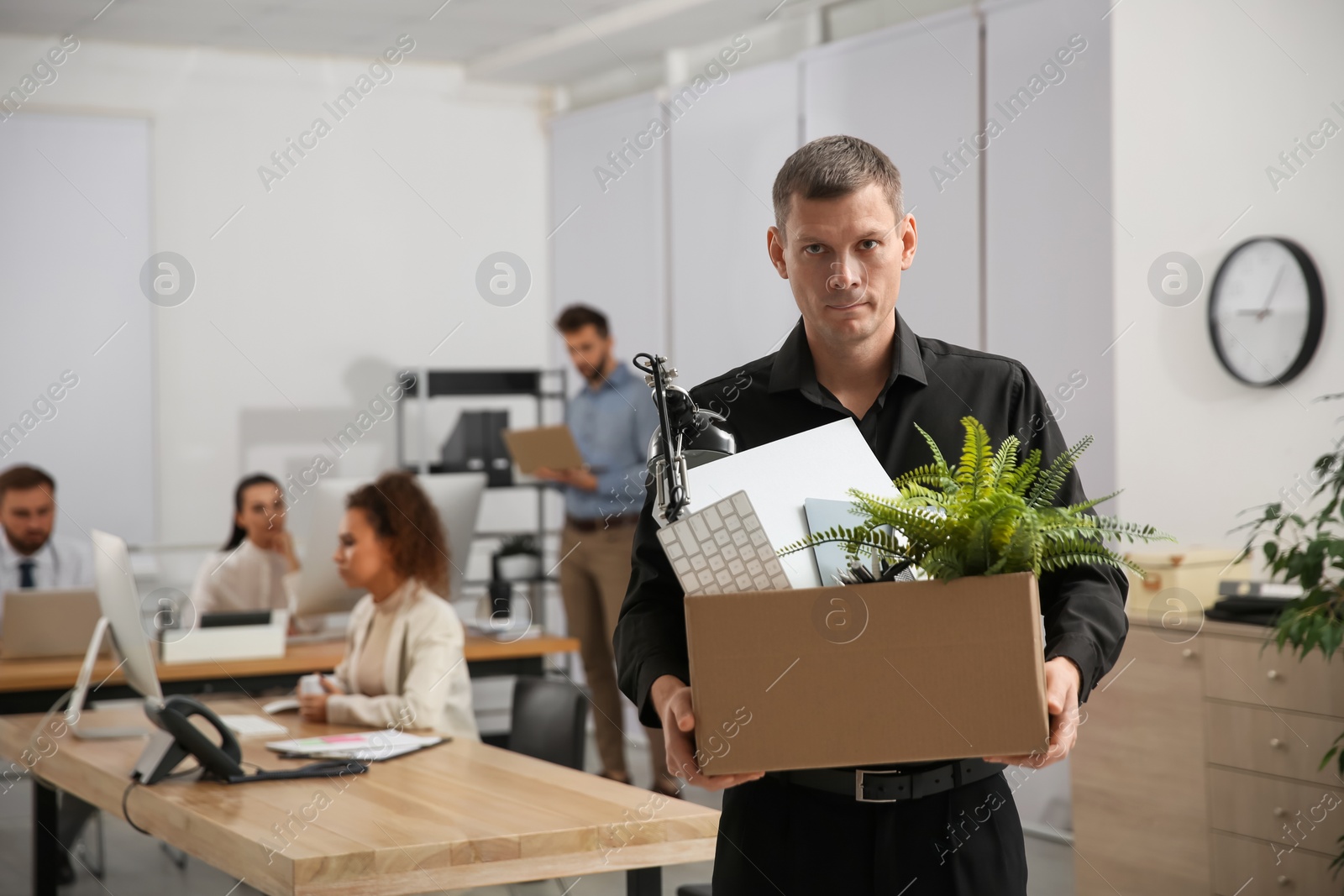 Photo of Upset dismissed man carrying box with stuff in office, space for text