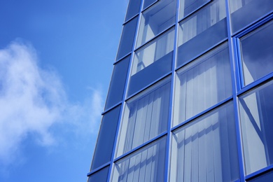 Photo of Modern office building with tinted windows against blue sky