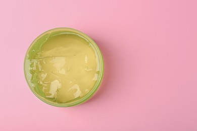 Photo of Jar of aloe gel on pink background, top view. Space for text