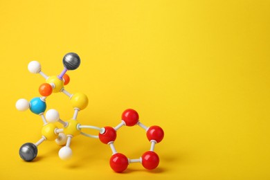 Photo of Structure of molecule on yellow background, space for text. Chemical model
