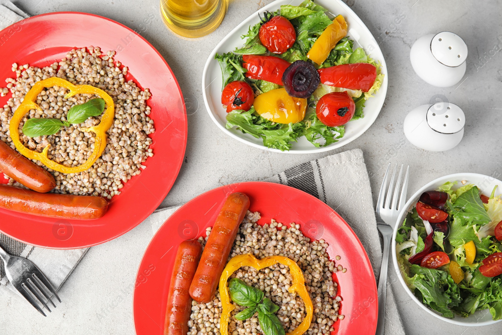 Photo of Tasty buckwheat porridge with sausages on light table, flat lay