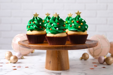 Christmas tree shaped cupcakes on white marble table