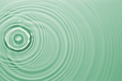 Image of Rippled surface of clear water on green background, top view