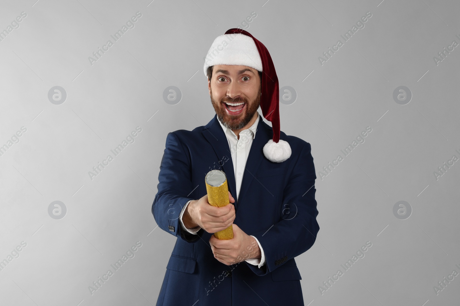 Photo of Emotional man with party popper on light grey background