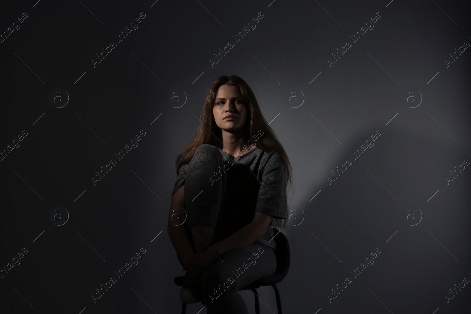 Photo of Depressed young woman on gray background