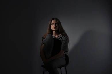 Photo of Depressed young woman on gray background