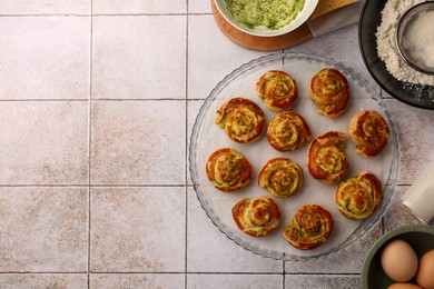 Fresh delicious puff pastry and ingredients on white tiled surface, flat lay. Space for text