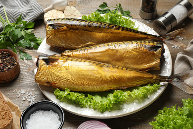 Tasty smoked fish served on wooden table