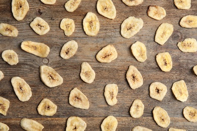 Flat lay composition with banana slices on wooden table. Dried fruit as healthy snack