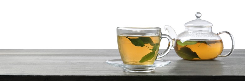 Photo of Refreshing green tea in cup and teapot on grey wooden table against white background