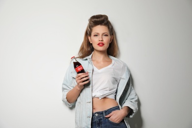 MYKOLAIV, UKRAINE - NOVEMBER 28, 2018: Young woman with bottle of Coca-Cola on white background