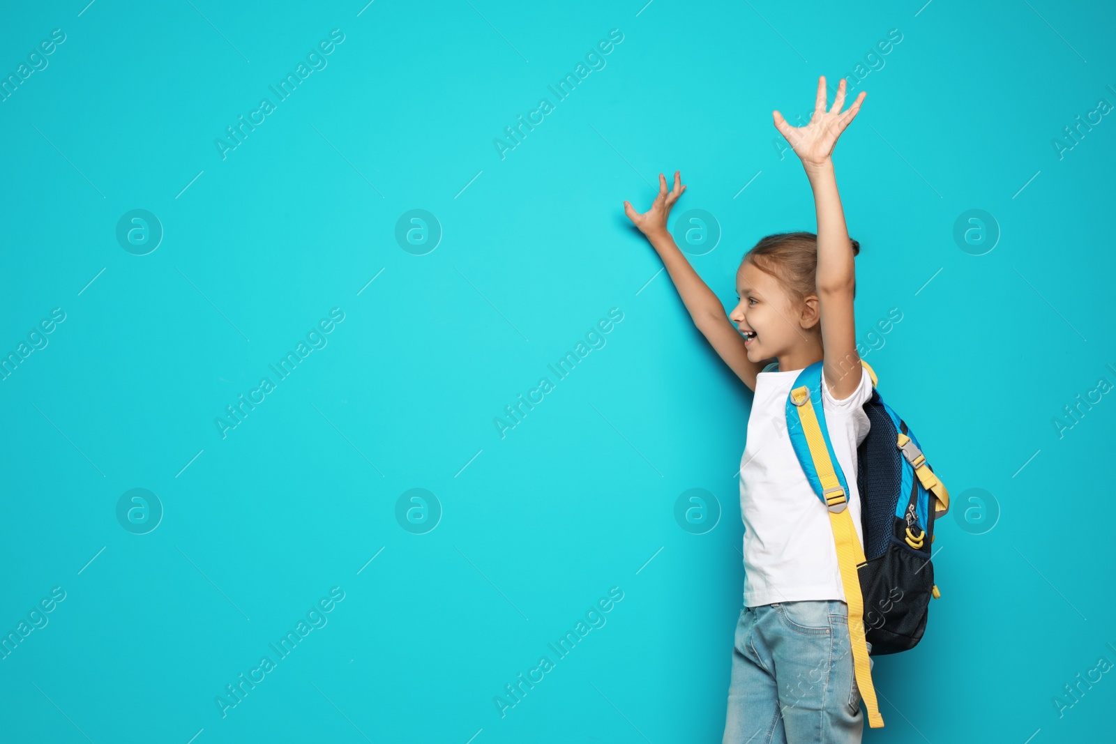 Photo of Little school child with backpack on color background