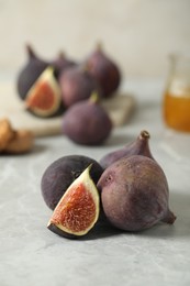 Photo of Tasty raw figs on light grey marble table. Space for text