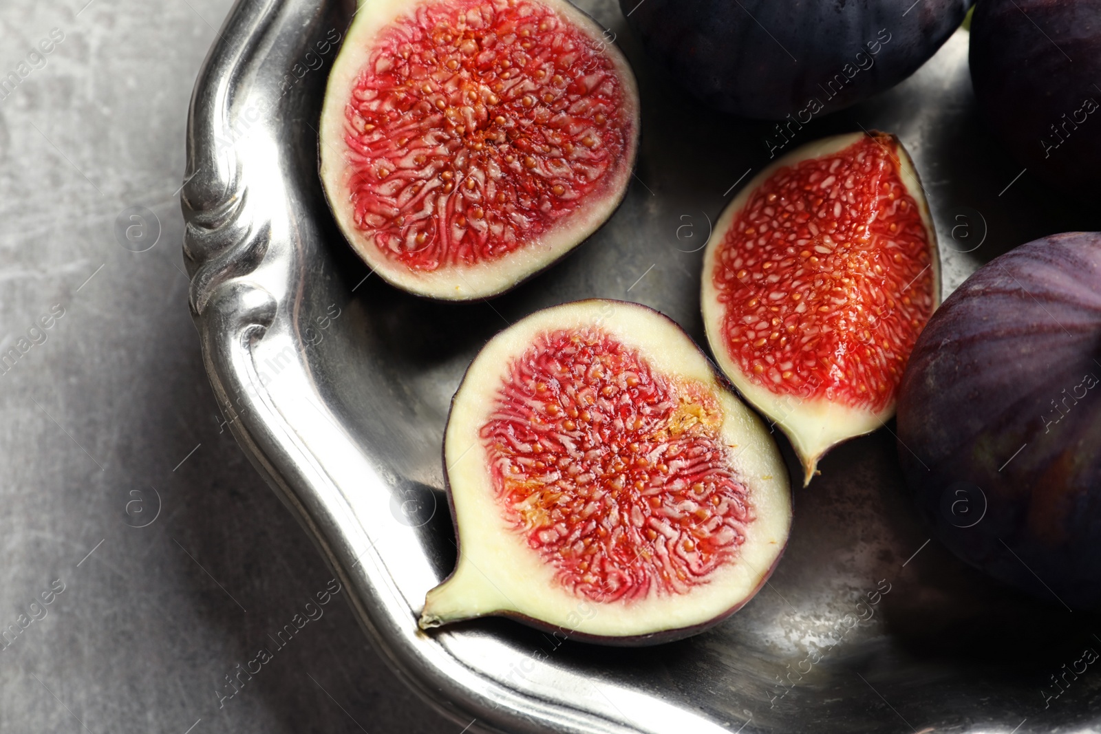 Photo of Dish with fresh ripe figs on gray background, top view