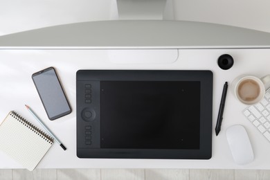 Photo of Flat lay composition with graphic tablet and smartphone on white table, top view. Retoucher's workplace