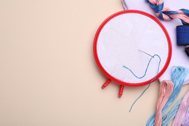 Photo of Flat lay composition with embroidery hoop on beige background. Space for text