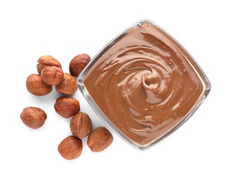 Bowl with delicious chocolate paste and hazelnuts on white background, top view
