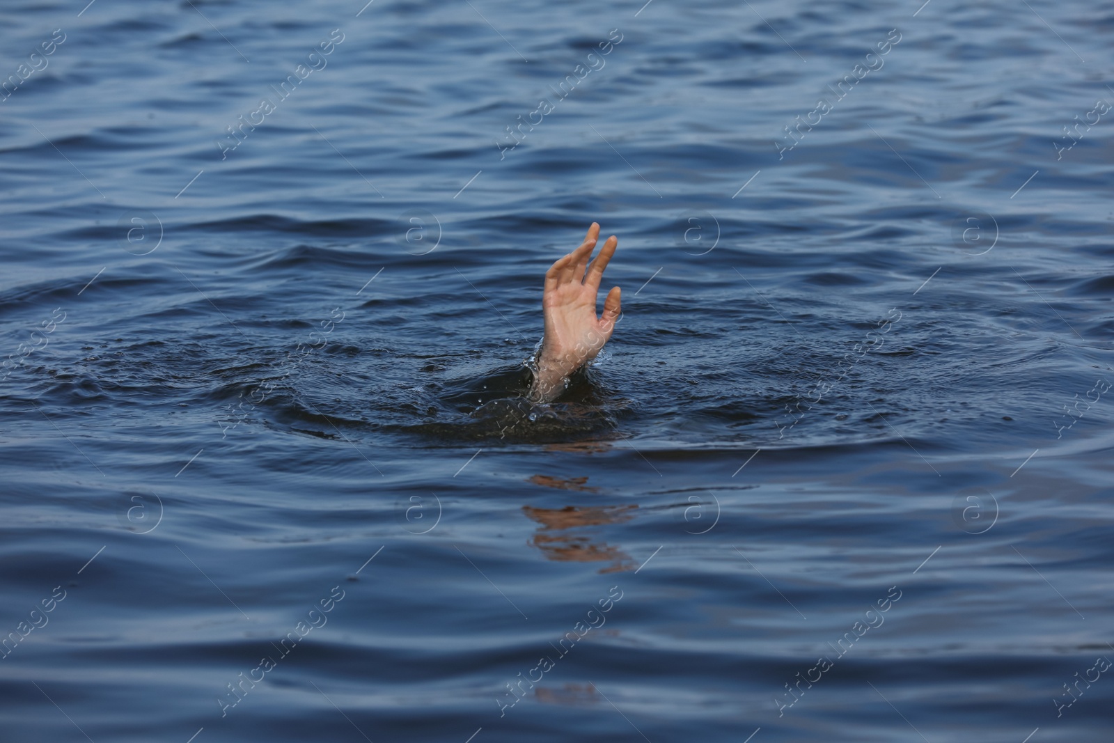 Photo of Drowning woman reaching for help in sea, closeup