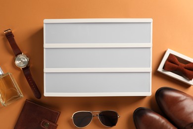 Photo of Blank letter board, men's accessories and shoes on orange background, flat lay. Mockup for design