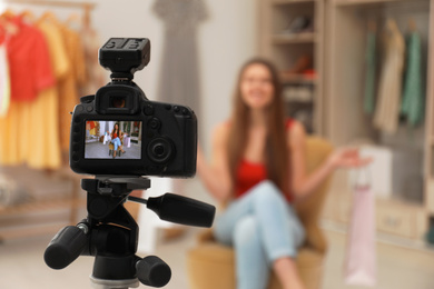 Photo of Fashion blogger recording new video in room, focus on camera