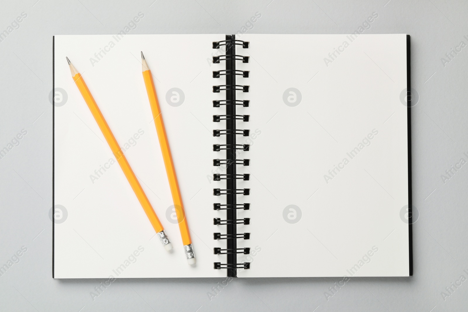 Photo of Notebook and pencils on gray background, top view