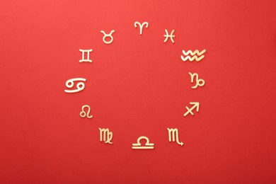 Zodiac signs on red background, flat lay
