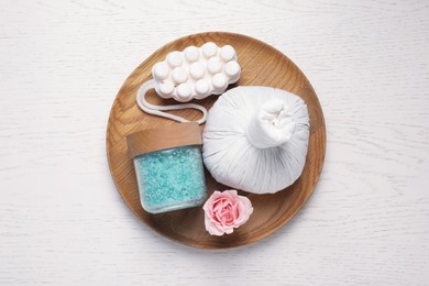 Composition of herbal bag and spa products on white wooden table, top view