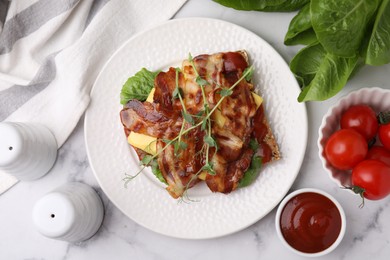 Photo of Tasty sandwich with bacon and microgreens served on white marble table, flat lay