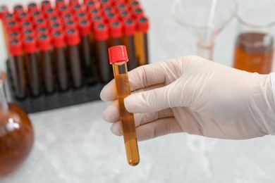 Photo of Scientist holding test tube with brown liquid, closeup