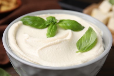 Photo of Delicious tofu sauce and basil leaves in bowl, closeup